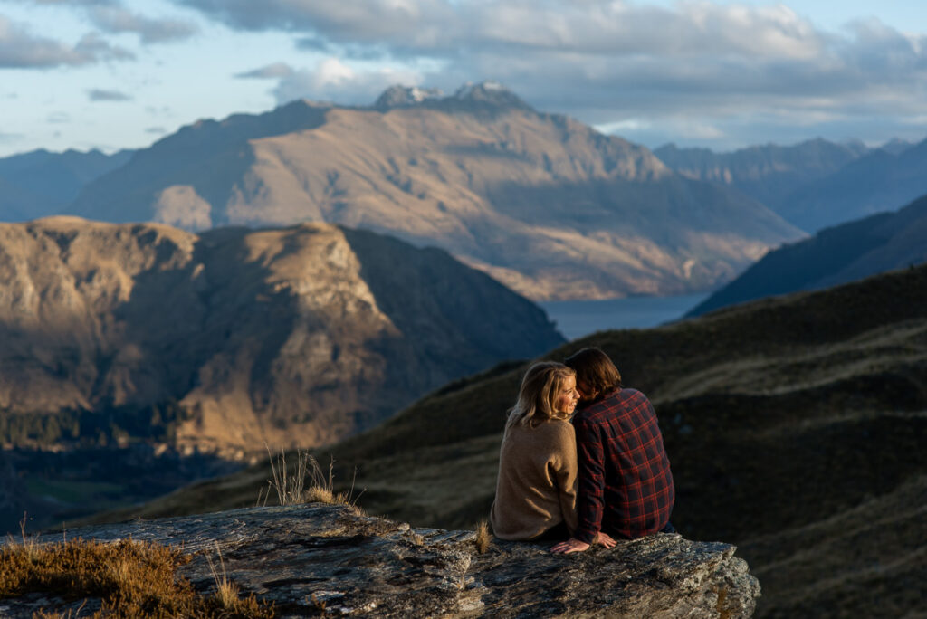 Queenstown Ben Lomond engagement, couple sitting on a rock at sunset and enjoying each others company