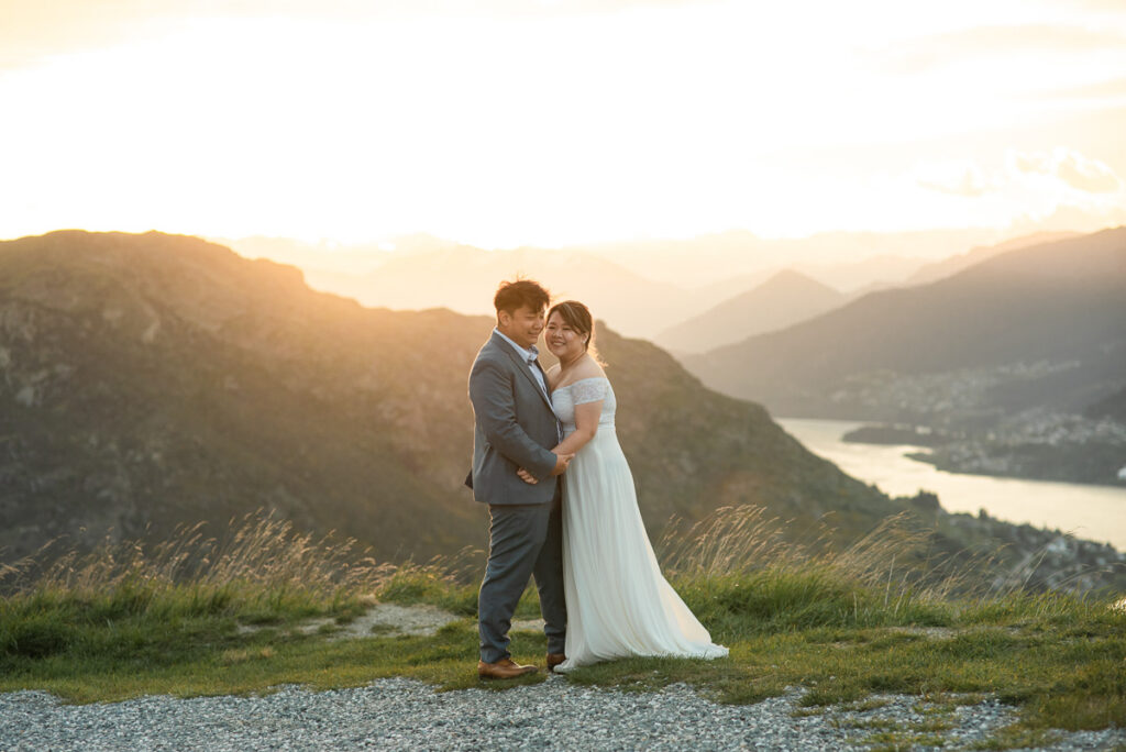 Bride and groom standing on Remarks white eloping at sunset