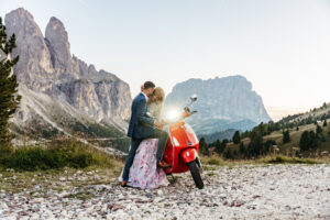 Vespa Elopement Dolomites with couple laughing with Sassolungo and Seceda in background