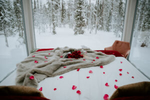 Akaslompolo Finland Winter Engagement glass cabins from Arctic Lodge with roses on bed