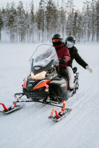 Akaslompolo Finland Winter Adventure Engagement snowmobiling happy couple