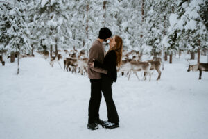 Akaslompolo Finland Winter Engagement couple in the snow with reindeer around