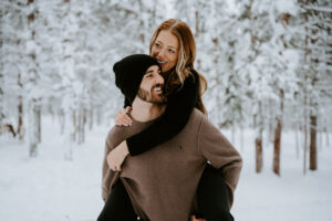 Akaslompolo Finland Winter Engagement piggy back ride with happy couple