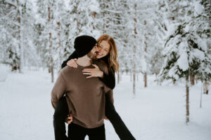 Akaslompolo Finland Winter Engagement piggy back ride in the snow