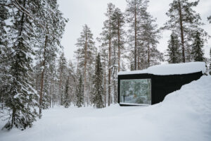 Akaslompolo Finland Winter Engagement glass cabin through the trees