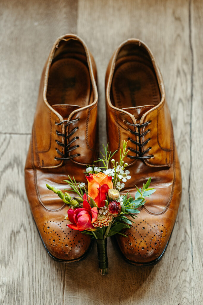 Boutonniere and men's shoes as elopement details for Dolomites elopement