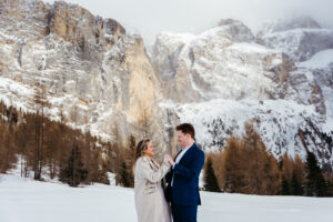 Passo Gardena Dolomites Winter Engagement, couple holding hands and smiling