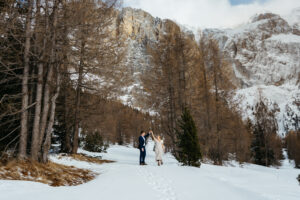 Passo Gardena Dolomites Winter Engagement, couple dancing in the snow with mountains and trees in background