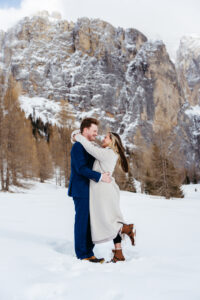 Passo Gardena Dolomites Winter Engagement, couple looks lovingly at each other in the snow