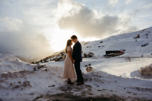 Couple at Passo Gardena in the Dolomites in winter embracing during engagement session