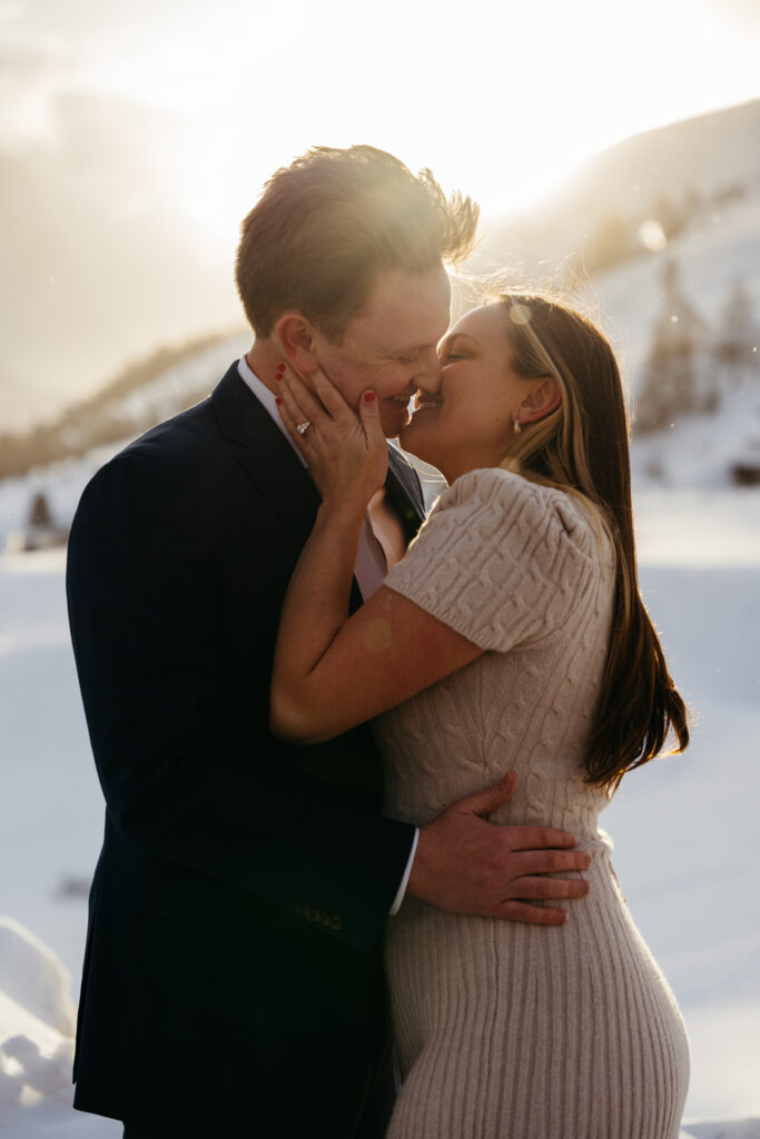 Couple during engagement session happily kissing in the snow in the Dolomites