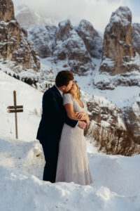 Passo Gardena Dolomites Winter Engagement, nice sunset light with couple embracing in the snow