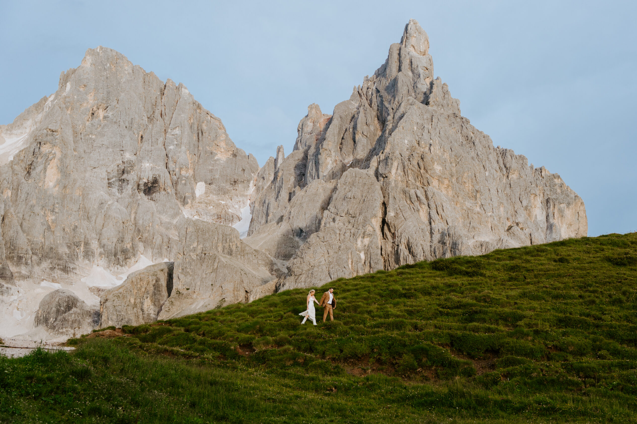 Couple eloping at Passo Rolle in the Dolomites with wildflowers