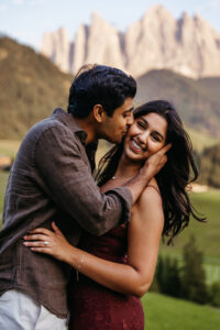 Man kisses woman's cheek at Val di Funes