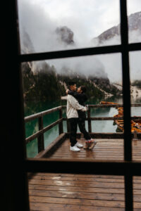 Creative through the window photo of couple during Lago di Braies engagement