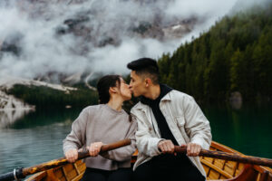 Newly engaged couple kissing during boat ride at Lago di Braies