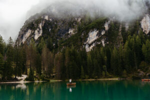 Couple standing on boat with beautiful green blue water of Lago di Braies