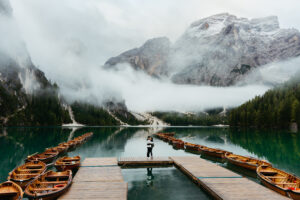 Couple hugging from afar at Lago di Braies on boathouse dock