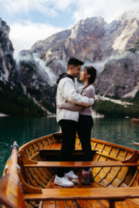 La Palifitta boathouse with engaged couple standing on boat at Lago di Braies