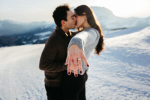Vegan couple newly engaged showing engagement ring in the snow
