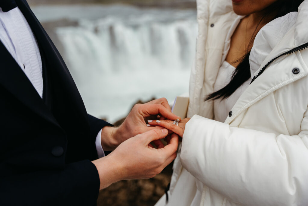 Detail photo of rings during Iceland elopement with Godafoss waterfall in the background