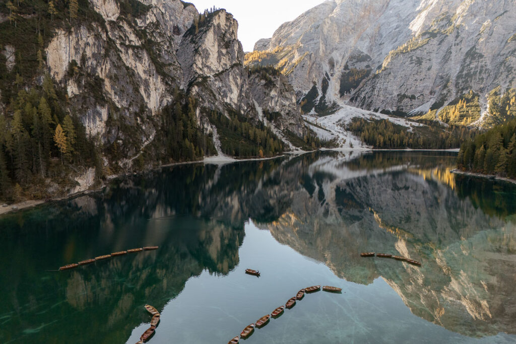 Drone photo of Lago di Braies with a bride and groom paddling at sunrise