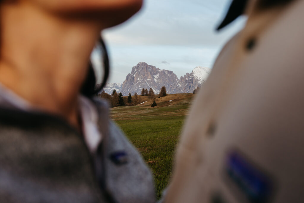 Seiser Alm in the background of artsy photo of man and woman after they got engaged in the Dolomites