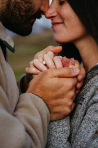 Close up of man and woman and engagement ring poking out