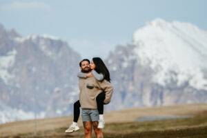 Man giving Woman piggy back ride in the Dolomites on Alpe di Siusi