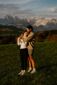 Newly engaged couple basking in sun at sunset at Alpe di Siusi in the Dolomites