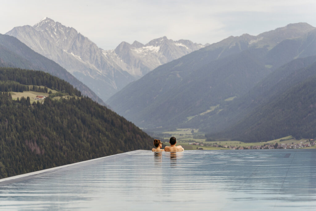 Bride and groom going for an afternoon swim with a view in the Dolomites at Hotel Hubertus. Why you should have a multi-day elopement