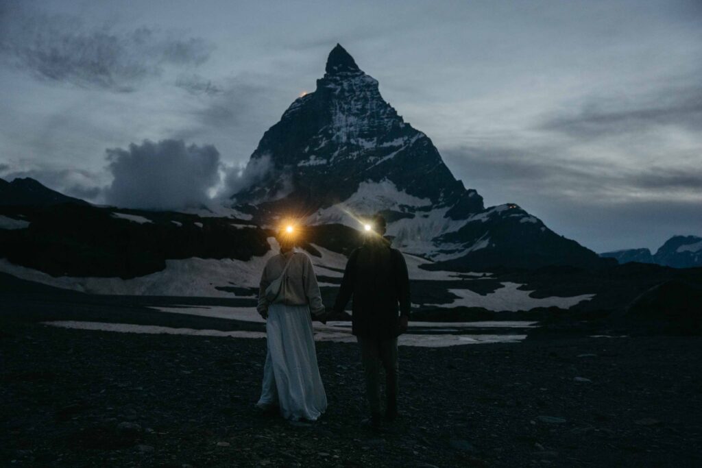 Bride and groom with headlamps in front of Matterhorn in Switzerland at night; Best Places to Elope on a Mountain in Europe