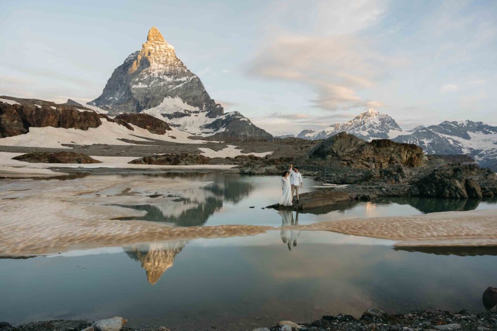Bride and groom walking out to reflective lake with Matterhorn mountain, one of the best places to propose in Europe