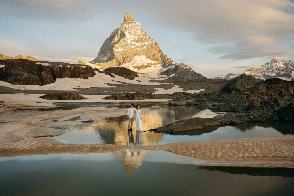 Bride and groom with their reflections in the water and the Matterhorn towering behind them