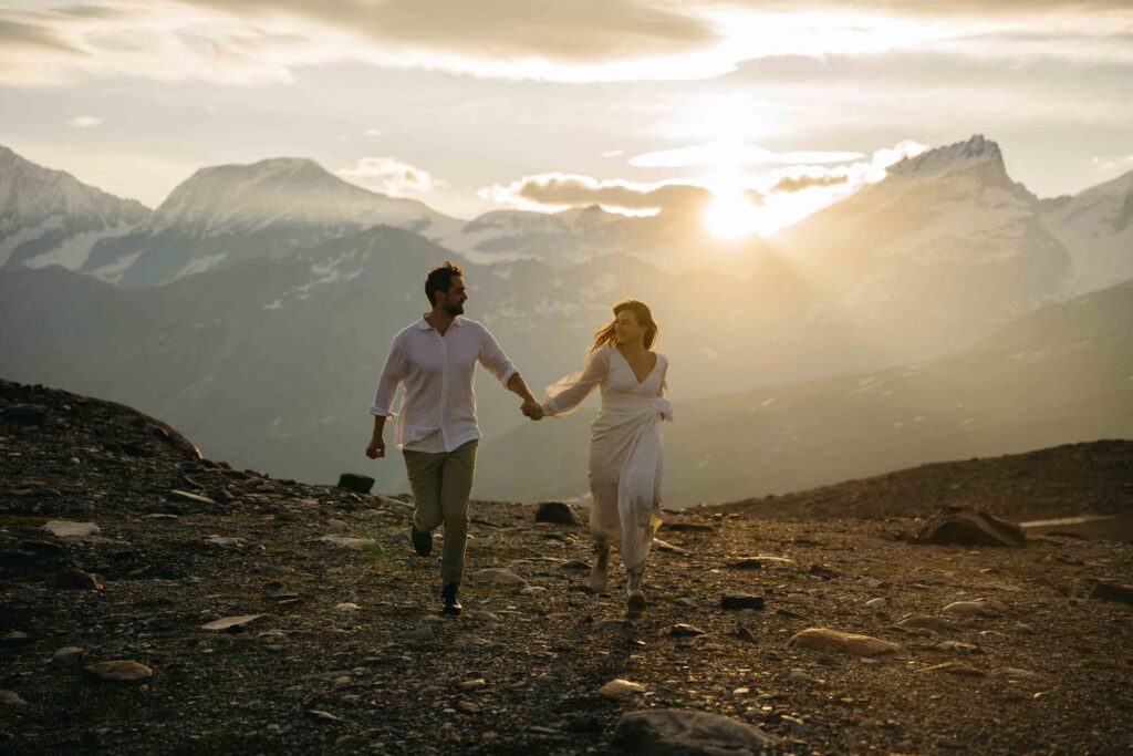 Bride and groom posing for wedding photos as they run through a field at sunrise in Switzerland