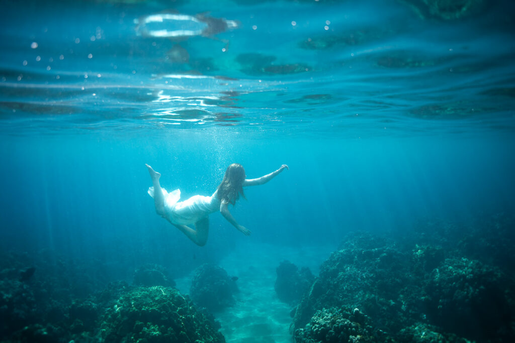Girl under water with white dress in Maui