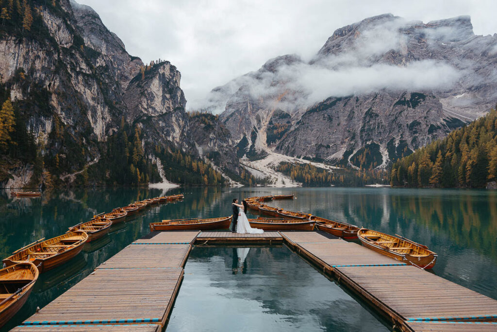 Autumn at lake Braies with bride and groom eloping on the dock