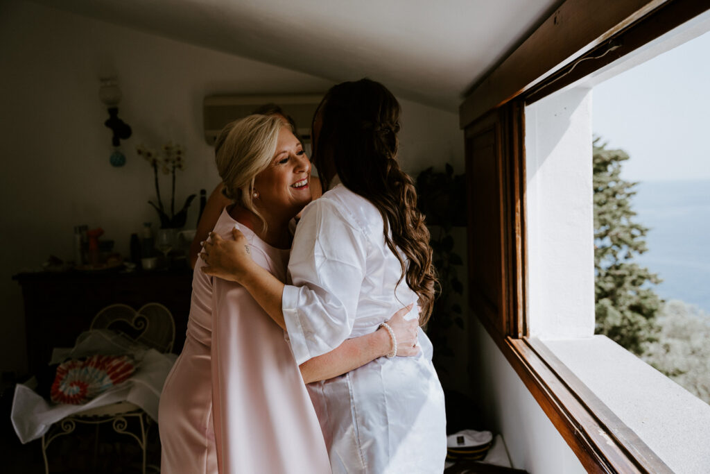 Mom hugging bride as she's getting ready for her wedding day in Positano