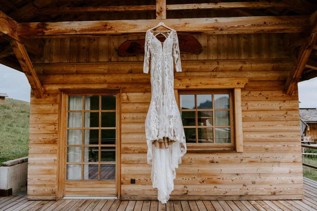 Vegan dress for vegan bride in the Dolomites hanging on a wooden post on a cabin