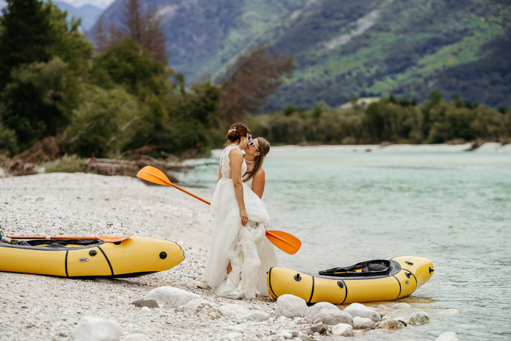 Bride and bride pack rafting in the Soča river in Slovenia on their adventure elopement