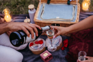 Fiance pouring his fincee wine as they enjoy a vegan picnic courtesy of Paradiso Pure Living hotel
