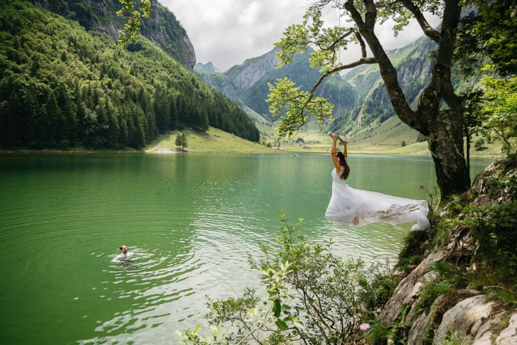 Bride rope swing into Seealpsee in Switerland on her elopement day; How to Elope in Switzerland