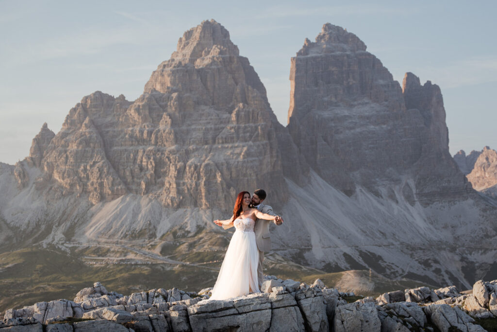 Bride and groom with airplane arms at Tre Cime, the Dolomites are one of the top 10 places to Elope in Europe