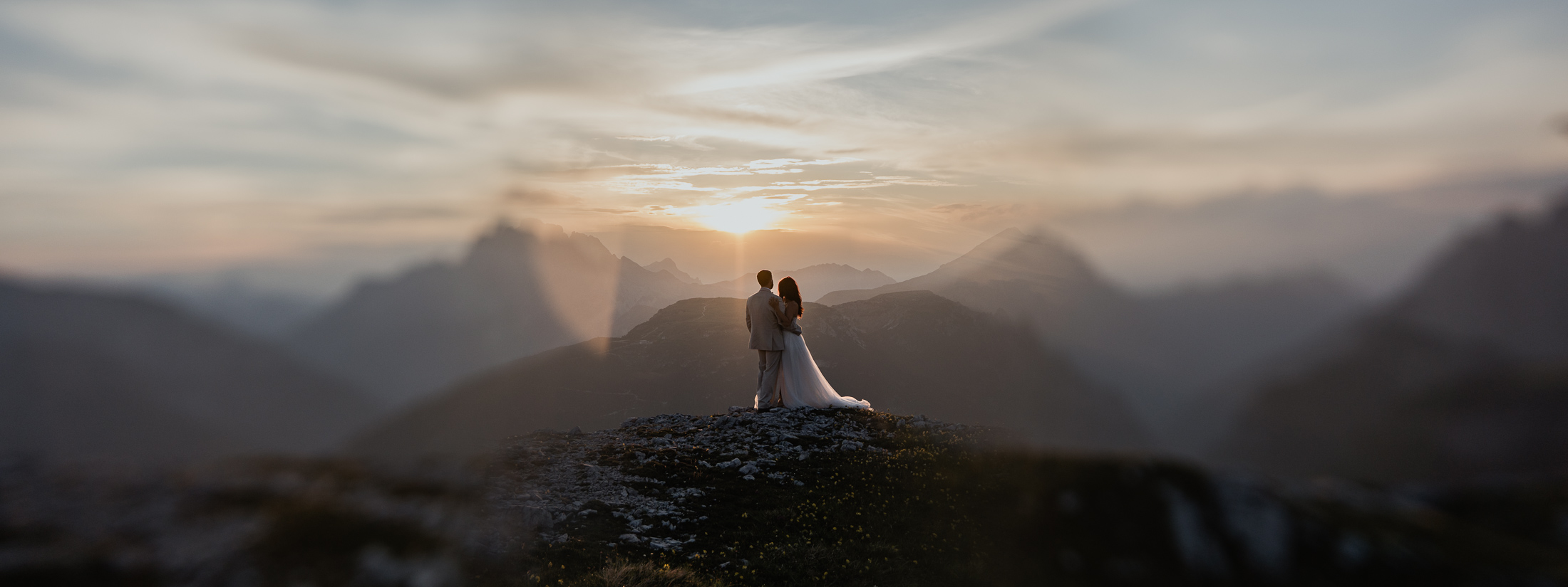 Mountain elopement in the Dolomites with bride and groom against sunset, wanting a cool summer elopement and to avoid heatwaves and fires