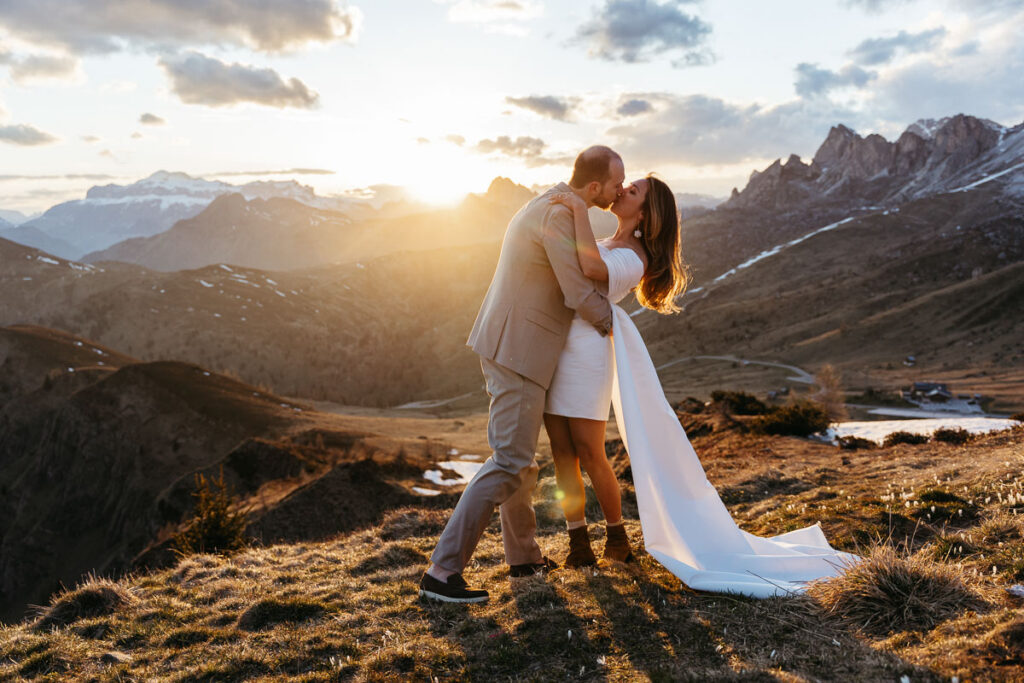 Sunset at Passo Giau with bride and groom kissing after they read their vows during their eco-friendly wedding