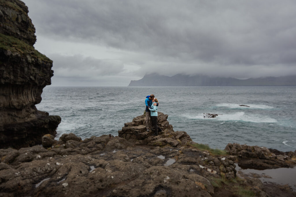 Bride and groom in casual clothes at Gjógv on the Faroe Islands posing at a cliff edge