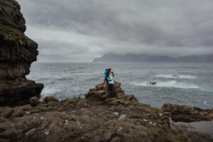 Bride and groom in casual clothes at Gjógv on the Faroe Islands posing at a cliff edge