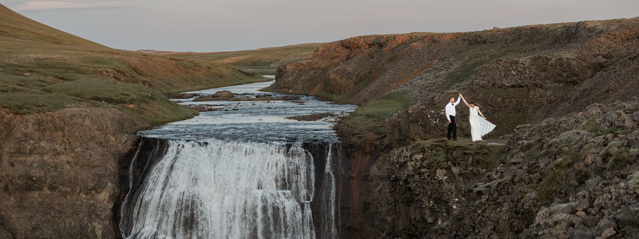 Bride and groom on a cliff at Þorufoss in Iceland; Iceland elopement guide
