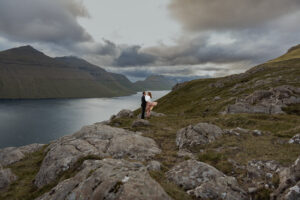 Bride and groom wanted a cool summer elopement to escape the heatwaves and fires, so here they are eloping in Faroe Islands on Klakkur with the mountains and Fjords in the background