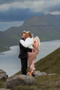 Bride and groom embracing the wind on the Faroe Islands